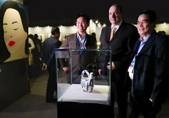 出席展会的嘉宾在参展的艺术品前合影