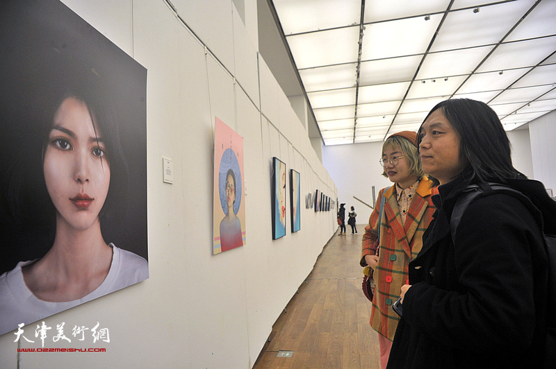 郝青松与青年艺术家在展览现场观看作品.