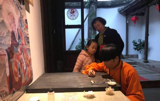 市民正在观赏唐卡画师作画。
