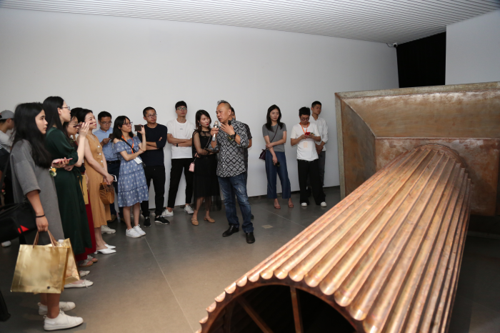 ▲参展艺术家管怀宾向观众讲解自己的作品《烁远》