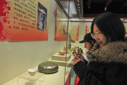 观众在现场观看带有吉语纹饰的清宫文物。