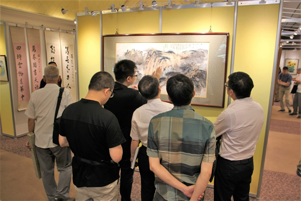 图/ 2018帝图艺术夏季拍卖会预展现场藏家观赏张大千《黄山云松图》作品。