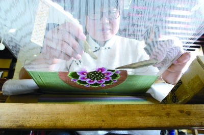 传承人在缂织莲藕图 （李欣然 摄）